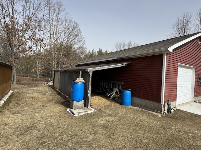 exterior space with an outdoor structure, concrete driveway, and a garage