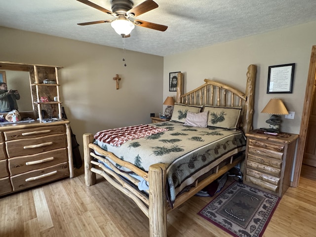 bedroom with a textured ceiling, ceiling fan, and wood finished floors