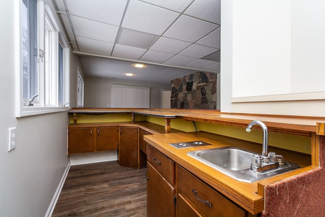 4355 S Lapeer Rd, Metamora, MI 48455 - kitchen with brown cabinets, a sink, a drop ceiling, dark wood finished floors, and baseboards