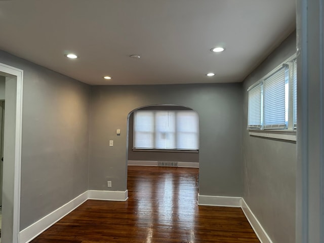 unfurnished room featuring recessed lighting, wood finished floors, visible vents, and baseboards