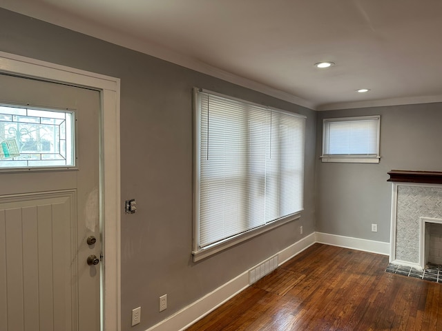 unfurnished living room with dark wood finished floors, visible vents, a fireplace, and baseboards