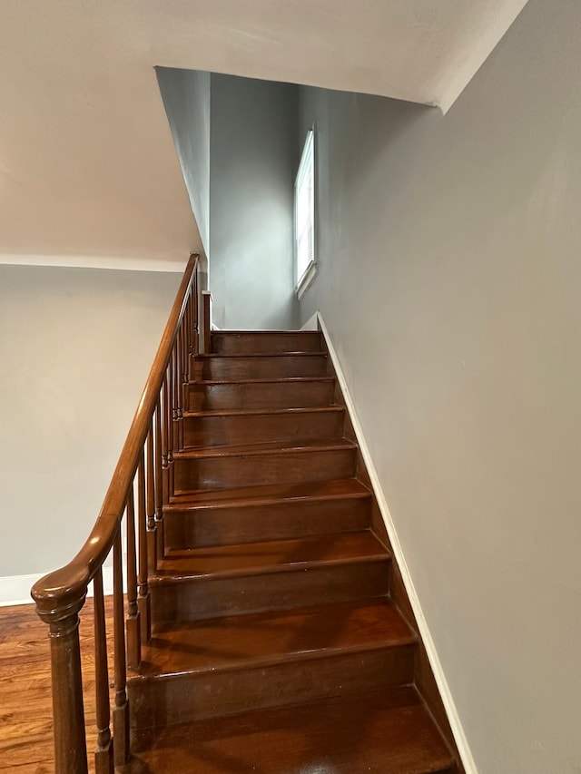 stairs featuring baseboards and wood finished floors