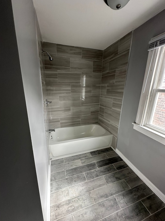 full bath featuring baseboards, shower / washtub combination, and wood tiled floor