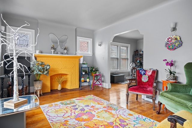 living area featuring arched walkways and wood finished floors