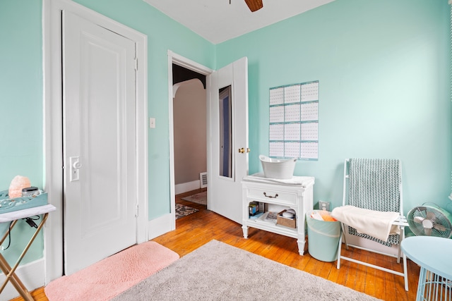 bedroom with wood finished floors, baseboards, and arched walkways