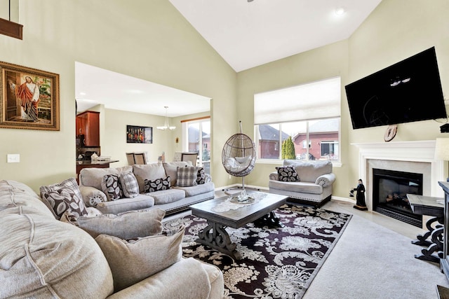 living area featuring baseboards, a fireplace with flush hearth, high vaulted ceiling, and a chandelier