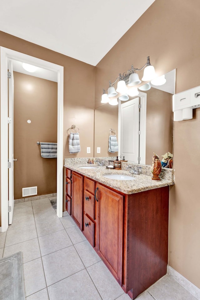 full bath with a sink, visible vents, double vanity, and tile patterned flooring