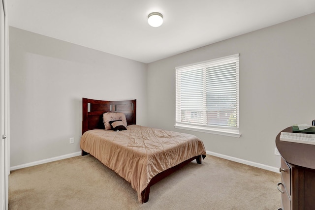 bedroom featuring light colored carpet and baseboards