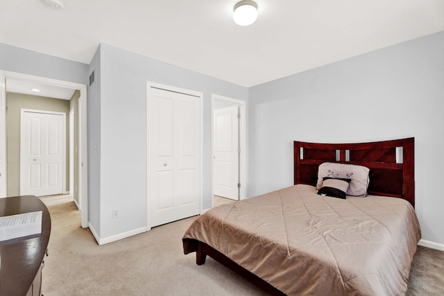 carpeted bedroom featuring a closet and baseboards