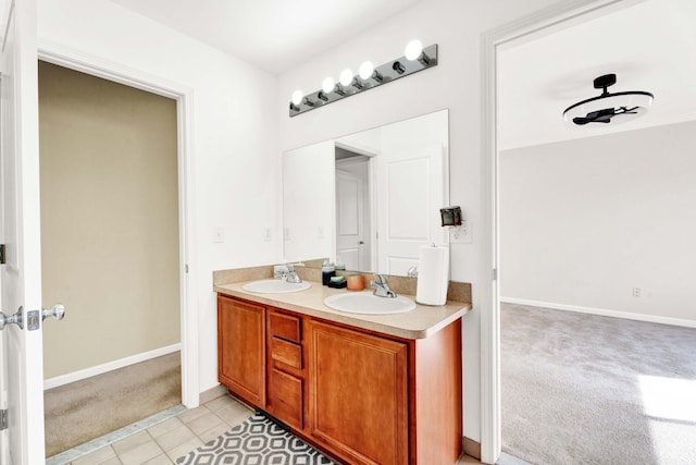 bathroom featuring double vanity, tile patterned floors, baseboards, and a sink