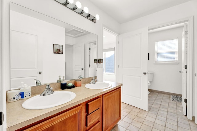 bathroom featuring a sink, toilet, double vanity, and tile patterned floors