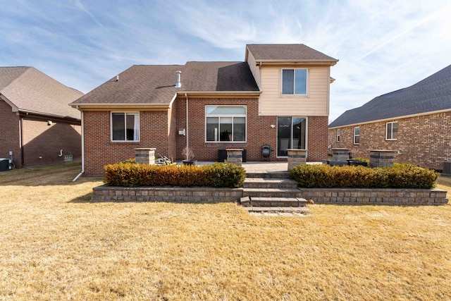 back of property with a patio, cooling unit, a shingled roof, a lawn, and brick siding