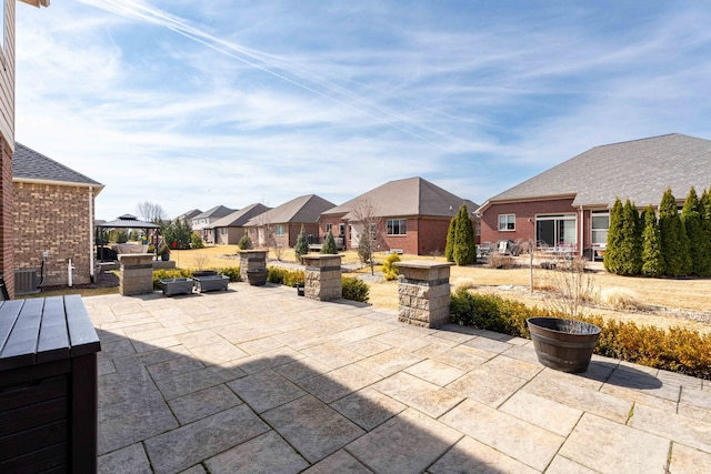 view of patio / terrace featuring a gazebo, a residential view, and central AC unit