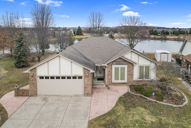 english style home featuring driveway, an attached garage, a shingled roof, french doors, and brick siding