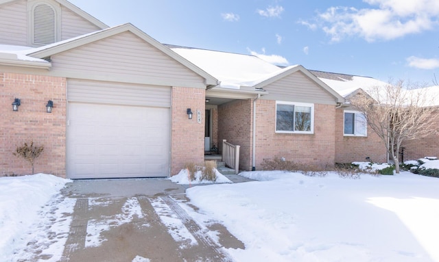 ranch-style home with a garage, brick siding, and driveway