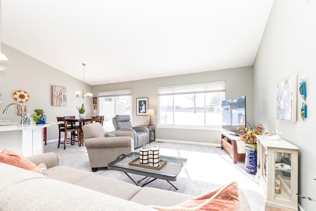 living room featuring vaulted ceiling, a notable chandelier, light colored carpet, and baseboards