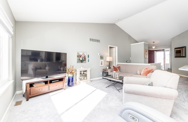 living area with visible vents, baseboards, carpet, and vaulted ceiling