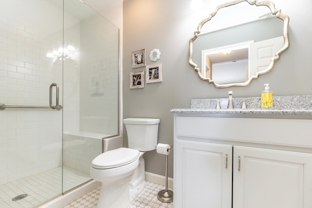 bathroom with vanity, toilet, baseboards, and a stall shower