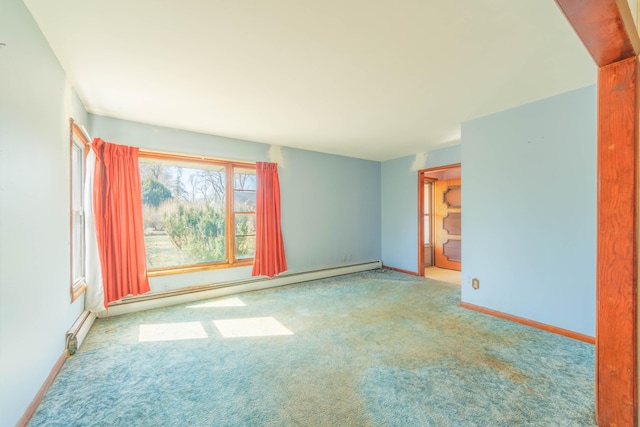 carpeted spare room with baseboard heating and baseboards