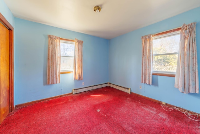 carpeted spare room with baseboards and baseboard heating