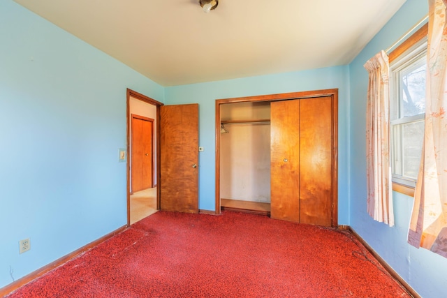 unfurnished bedroom featuring baseboards, a closet, and carpet floors