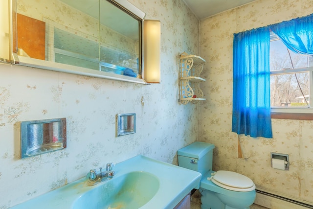 half bath featuring a baseboard heating unit, toilet, vanity, and wallpapered walls