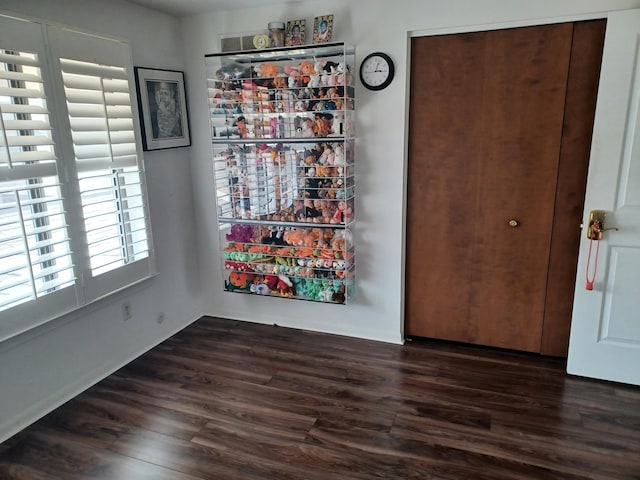 unfurnished dining area with dark wood-type flooring