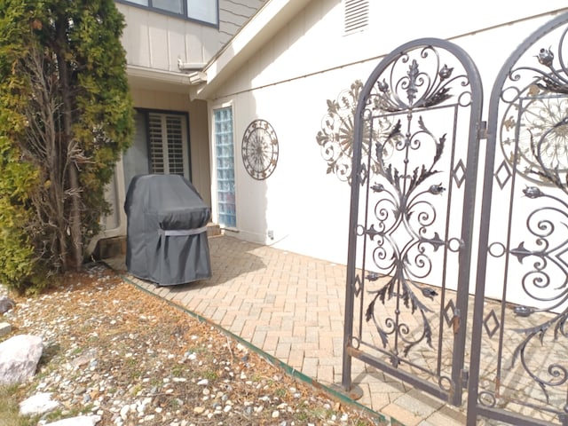 view of patio / terrace with a gate, visible vents, and grilling area