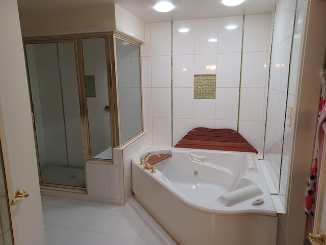 full bathroom featuring a tub with jets, tile walls, a shower stall, and tile patterned flooring