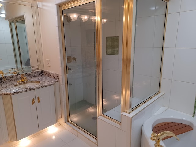 full bathroom featuring vanity, tile patterned floors, a garden tub, and a stall shower