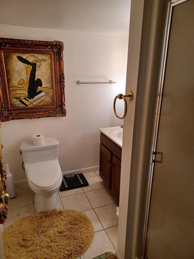 bathroom featuring tile patterned floors, baseboards, toilet, and vanity