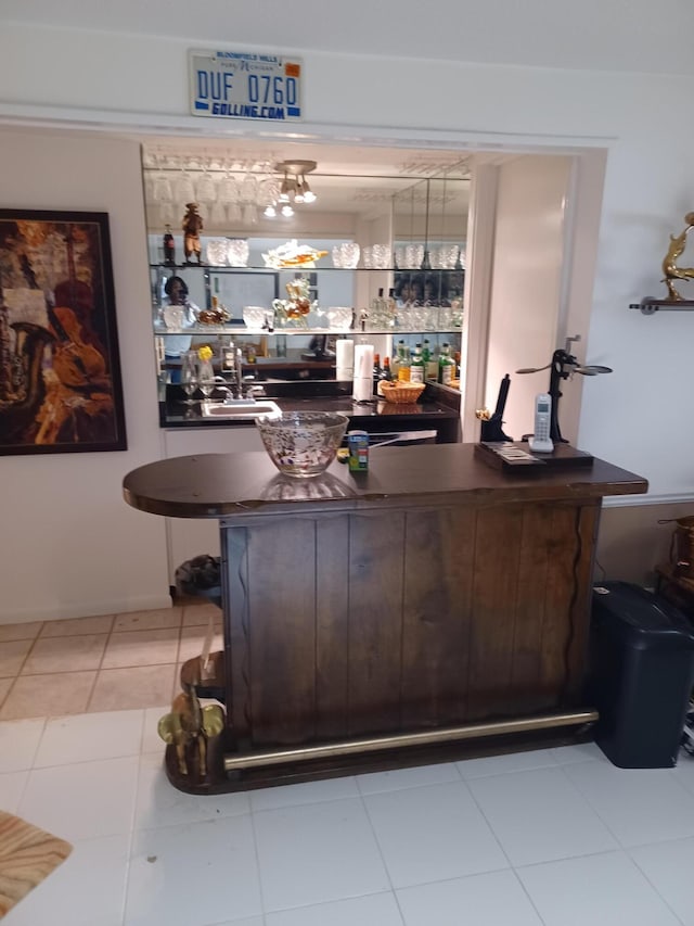 bar featuring tile patterned floors and bar