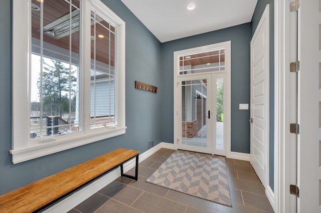 entrance foyer with a healthy amount of sunlight, baseboards, dark tile patterned flooring, and recessed lighting