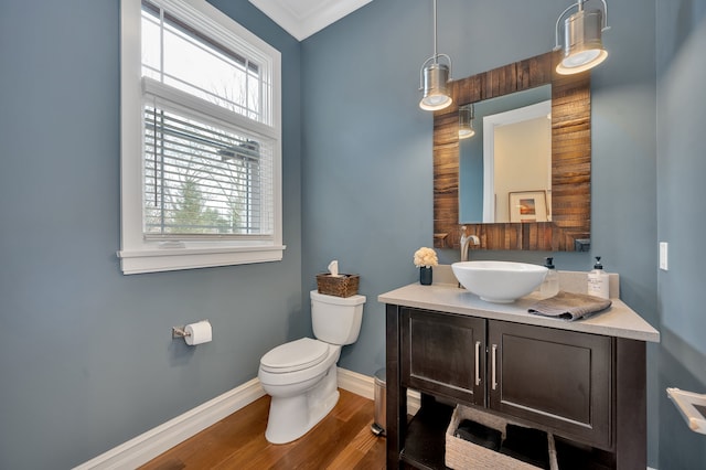 bathroom featuring baseboards, plenty of natural light, toilet, and vanity