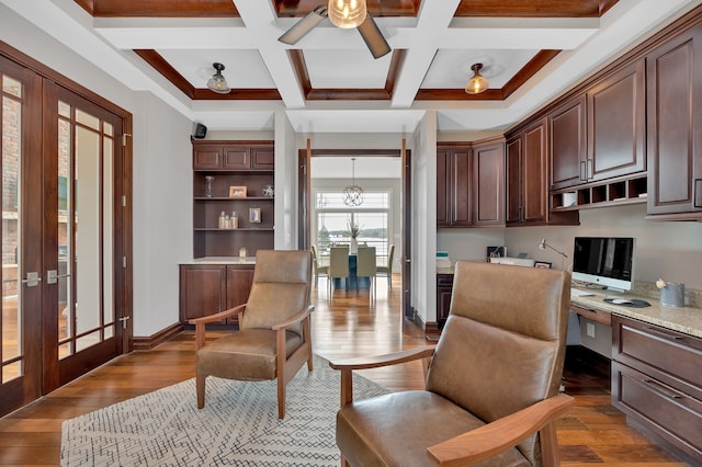 home office featuring french doors, beam ceiling, built in desk, wood finished floors, and coffered ceiling