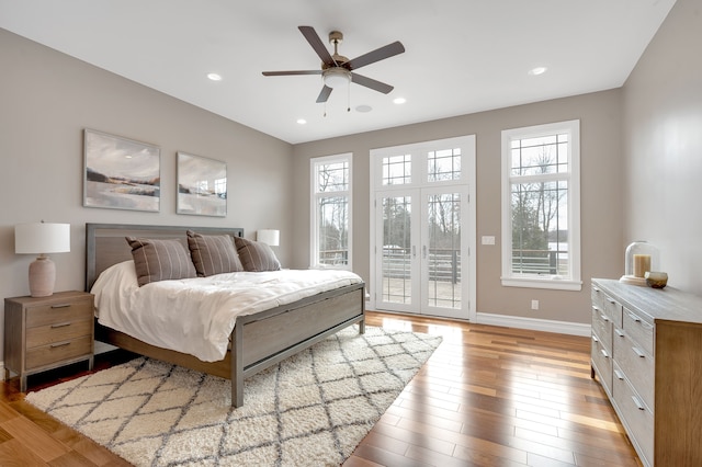 bedroom with access to outside, multiple windows, and light wood-style flooring