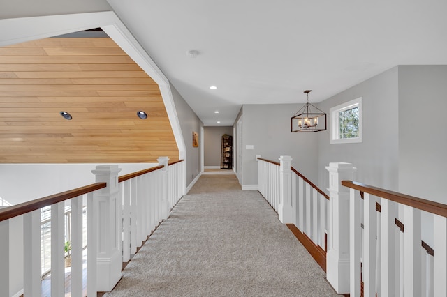 hallway with recessed lighting, carpet flooring, a notable chandelier, and an upstairs landing