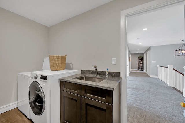 laundry area featuring baseboards, a sink, cabinet space, and washer and clothes dryer