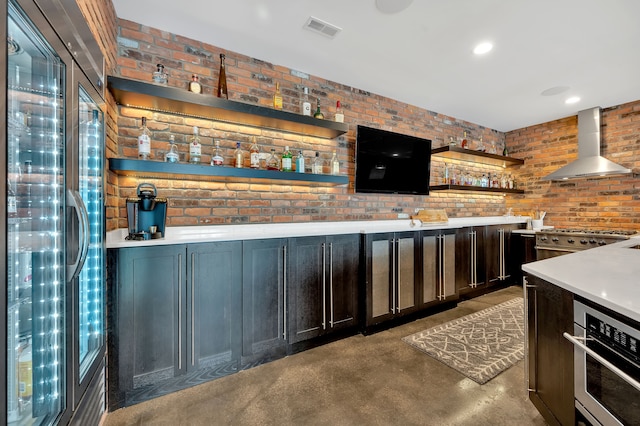 bar with visible vents, wall chimney range hood, bar, finished concrete floors, and appliances with stainless steel finishes