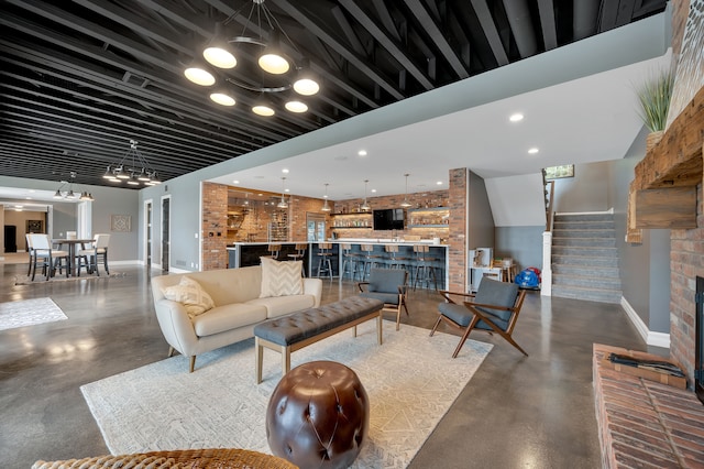 living room with stairs, baseboards, and finished concrete flooring