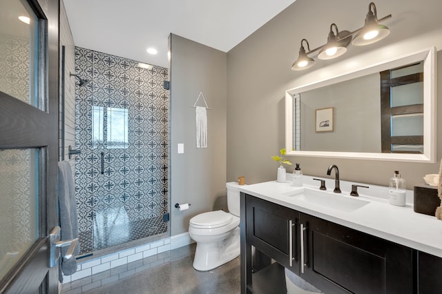 full bath with vanity, baseboards, a stall shower, and toilet