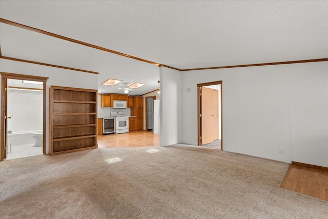 unfurnished living room featuring light colored carpet, a textured ceiling, lofted ceiling, and ornamental molding