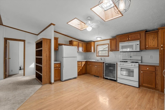 kitchen with wine cooler, white appliances, and brown cabinets