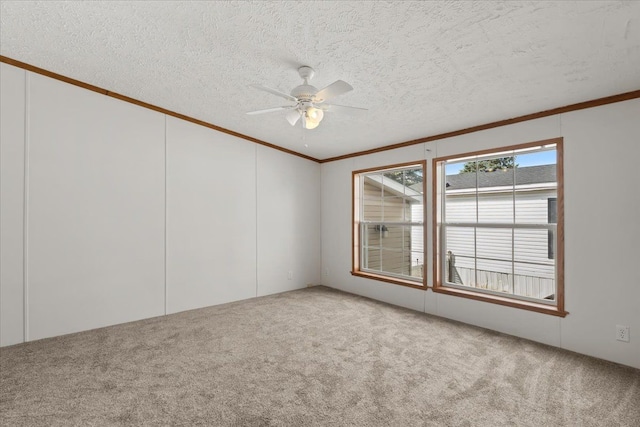 empty room with carpet flooring, a textured ceiling, crown molding, and a ceiling fan