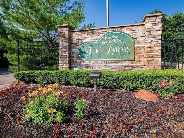 community / neighborhood sign featuring fence