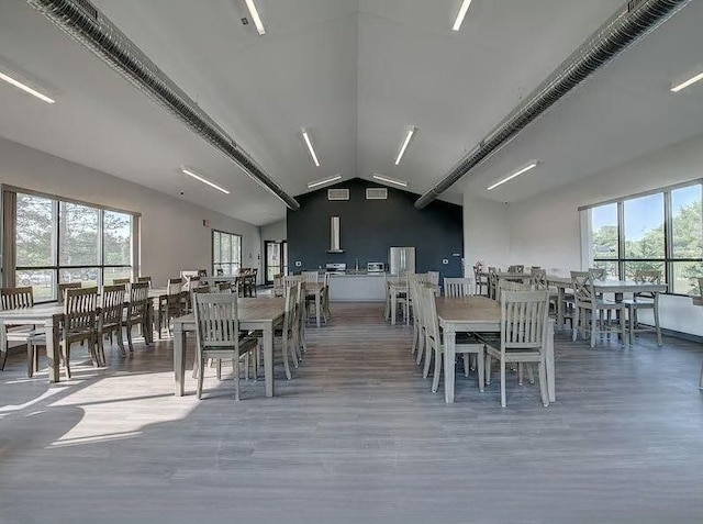 dining area with wood finished floors and vaulted ceiling