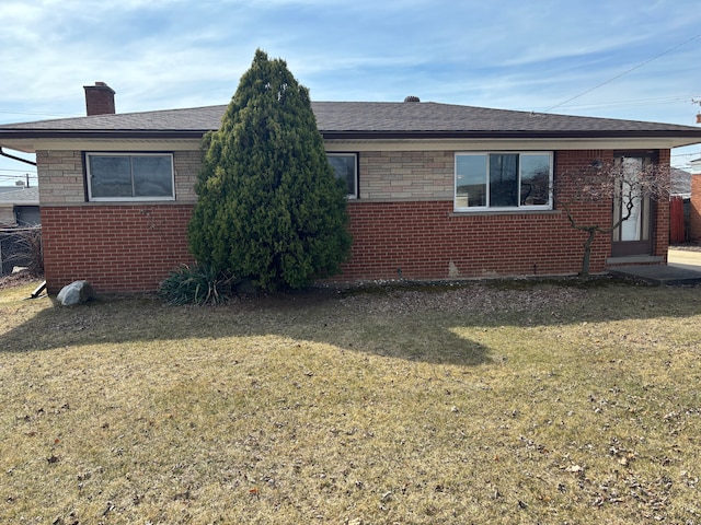 exterior space with a front lawn, brick siding, and a chimney