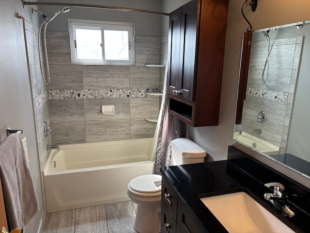 bathroom with shower / tub combination, wood finished floors, vanity, and toilet