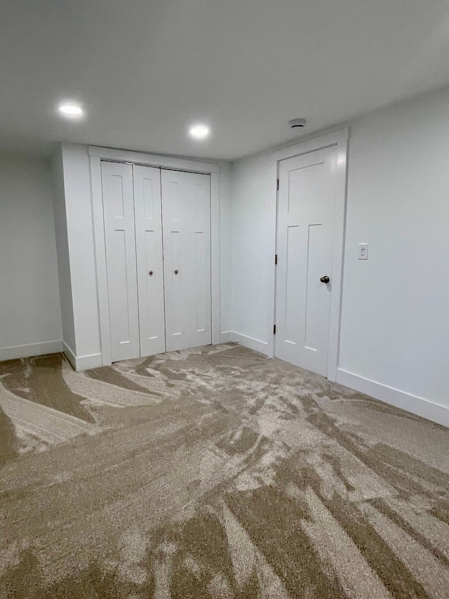 unfurnished bedroom with baseboards, carpet floors, and a closet