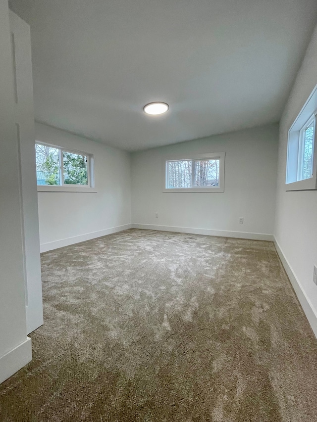 carpeted empty room with baseboards